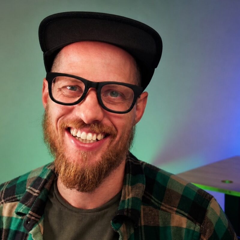 Kevin Kirchner grinning at the camera in a flannel shirt and ball cap